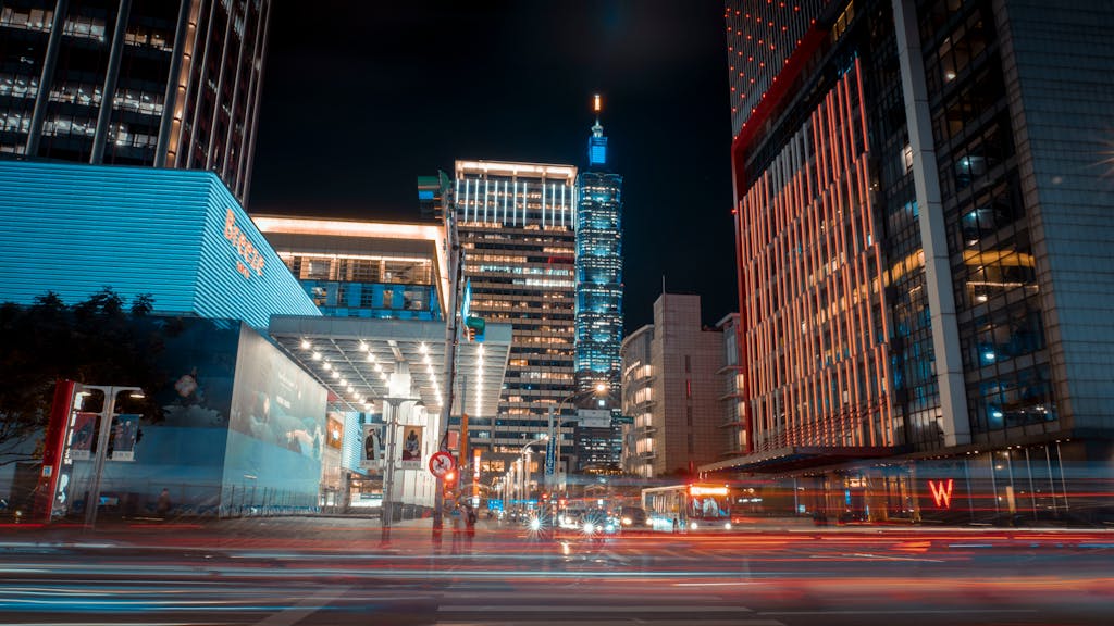 Stunning night shot of Taipei 101 surrounded by vibrant city lights and modern architecture.